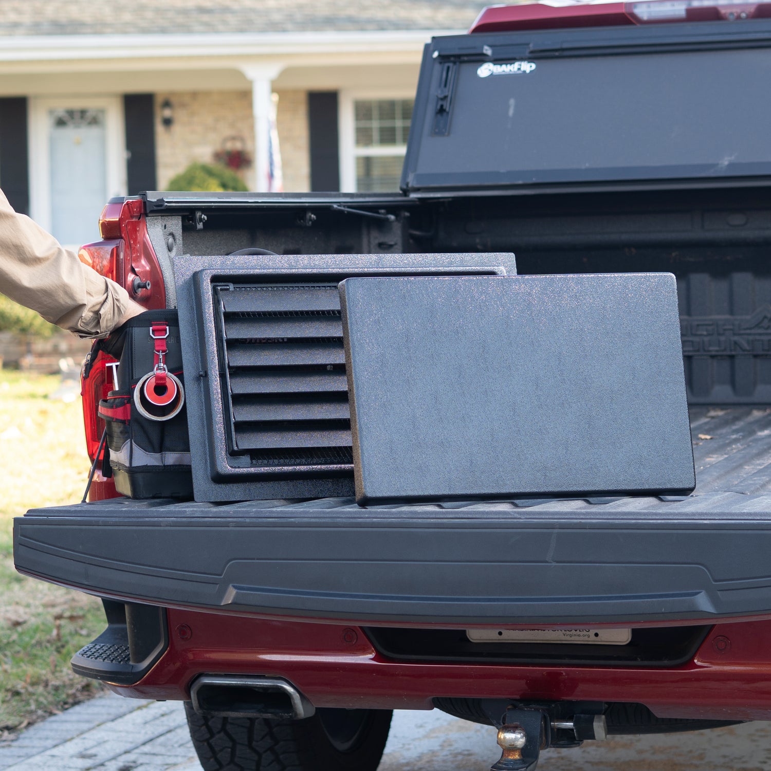 Black rectangular crawlspace door with  removable louvered air vents and a cover in a truck bed