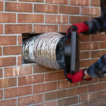 Person installing a duct system into a brick wall