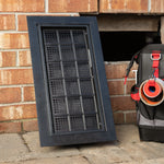 Outdoor air vent on a brick wall with a tool bag in the background