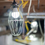 Wire cage light bulb in a crawl space setting