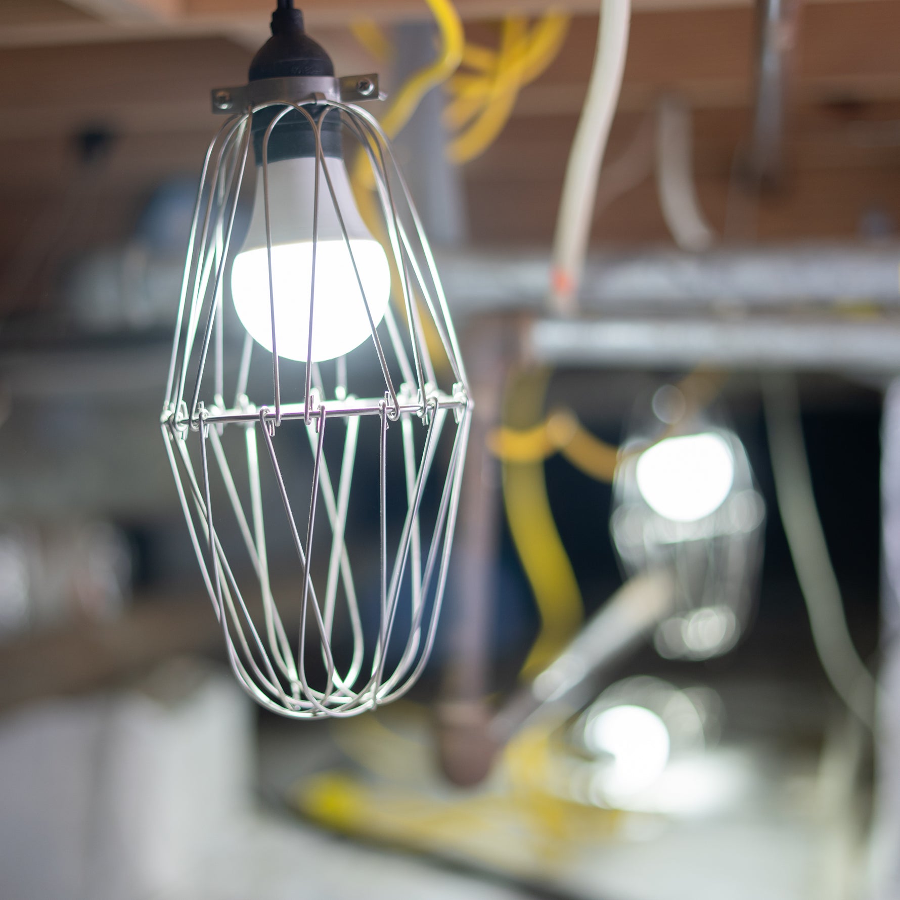 Wire cage light bulb in a crawl space setting