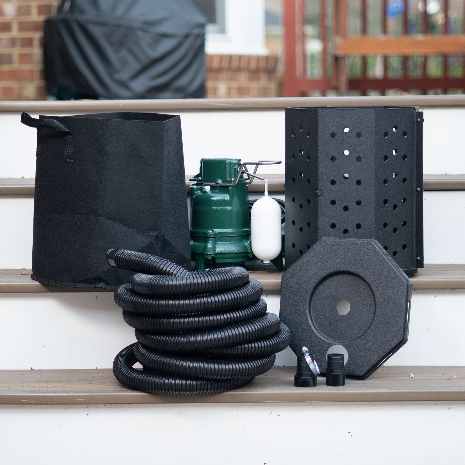 Sump pump, bag, bucket, hose, lids, and couplings on deck stairs