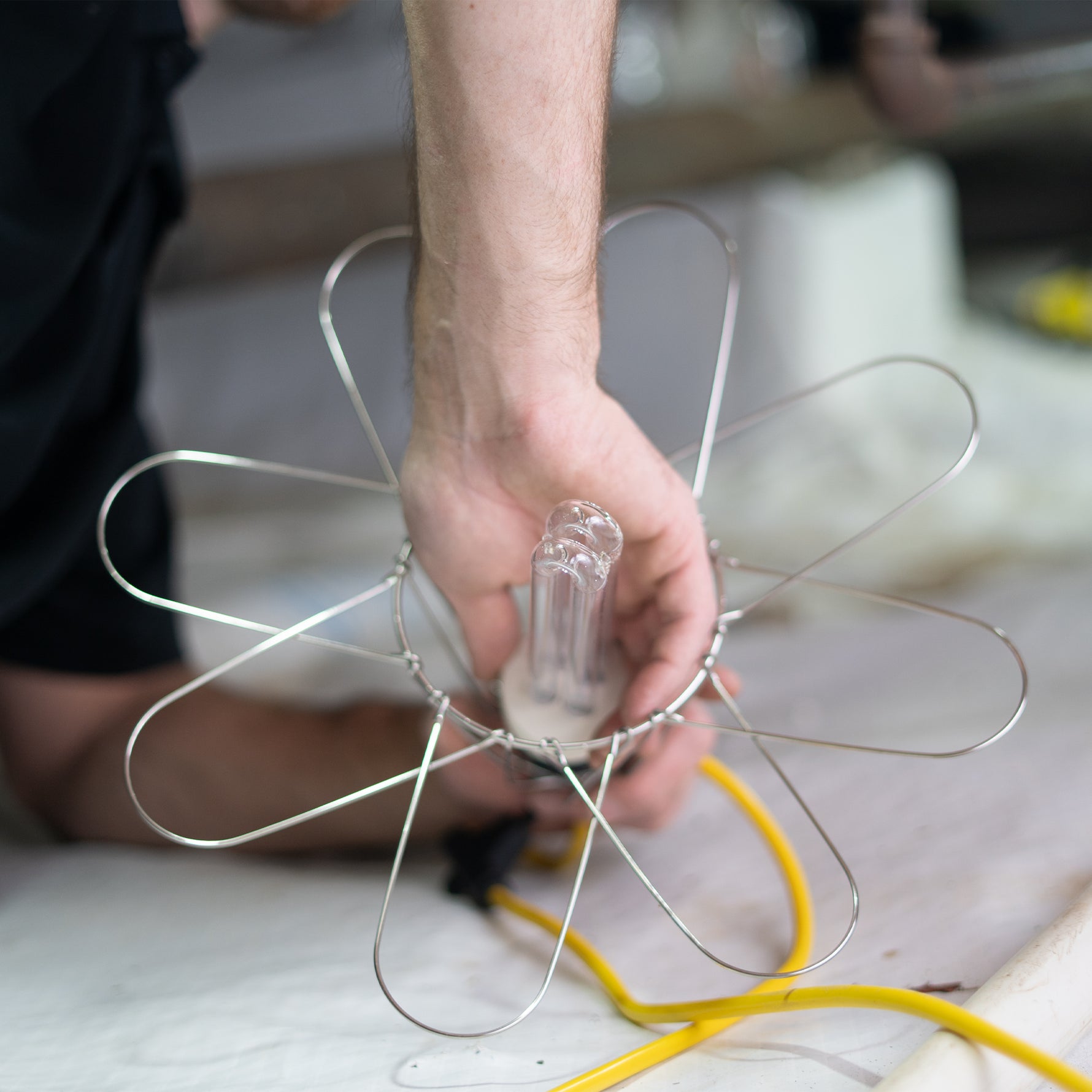 Person holding a light bulb with wiring on encapsulated crawl space floor