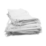 Stack of white fabric bags with fringes on a white background